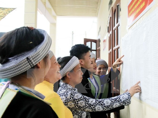 Đồng bào dân tộc Mông xã Quang Sơn, huyện Đồng Hỷ xem danh sách cử tri niêm yết tại Nhà văn hóa. (Ảnh: Thu Hằng/TTXVN)