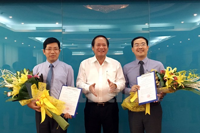 Bộ trưởng Trương Minh Tuấn (giữa) trao quyết định cho ông Lưu Đình Phúc (trái) và ông Đinh Tiến Dũng (phải). (Ảnh: CTV/Vietnam+)