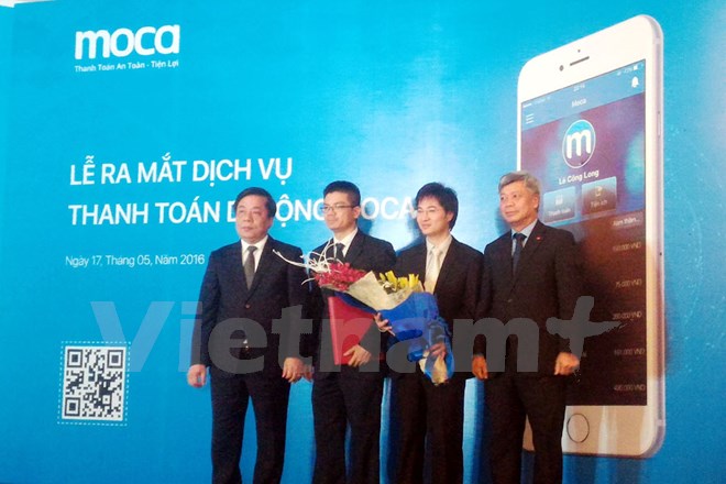 Phó Thống đốc Ngân hàng Nhà nước Nguyễn Kim Anh (trái) và Thứ trưởng Bộ Khoa học-Công nghệ Trần Việt Thanh (phải) cùng lãnh đạo MOCA tại lễ ra mắt dịch vụ. (Ảnh: T.H/Vietnam+)