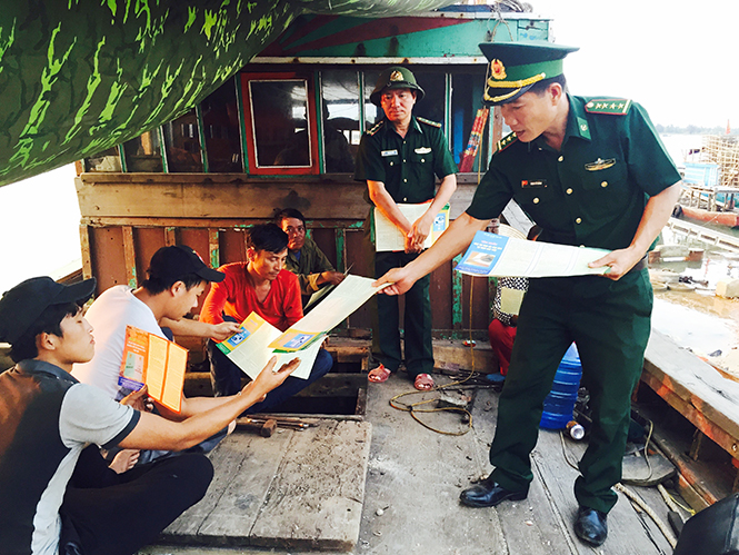 Cán bộ, chiến sỹ BĐBP tỉnh phát tờ rơi tuyên truyền bầu cử cho ngư dân xã Cảnh Dương (Quảng Trạch).