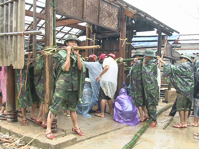 Ảnh 5 : Cán bộ, chiến sĩ Trung đoàn BB996 giúp dân xã Quảng Sơn (thị xã Ba Đồn) dựng lại nhà sau cơn bão số 10, năm 2013.