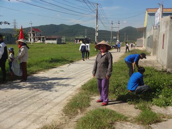 Các em học sinh và bà con khu dân cư thôn 10, xã Bắc Trạch tham gia phát quang cỏ dại, vệ sinh các tuyến đường.
