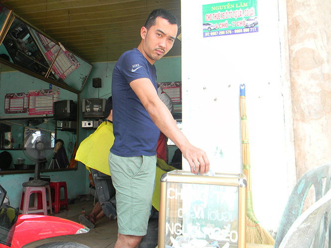 Một khách hàng quyên góp tiền hỗ trợ người nghèo tại quán cắt tóc Hoàng Việt.