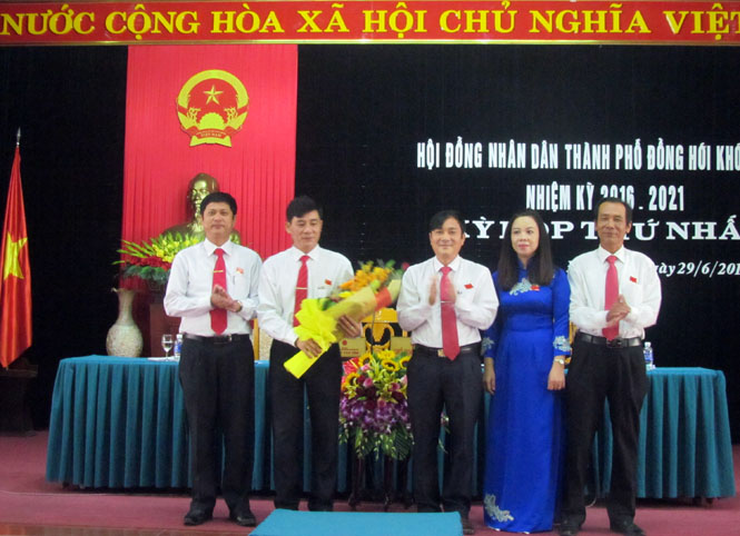 : Đồng chí Hà Quốc Phong, Phó Bí thư Thành ủy tặng hoa chúc mừng các đồng chí Chủ tịch, Phó Chủ tịch HĐND thành phố khóa XXI, nhiệm kỳ 2016-2021.