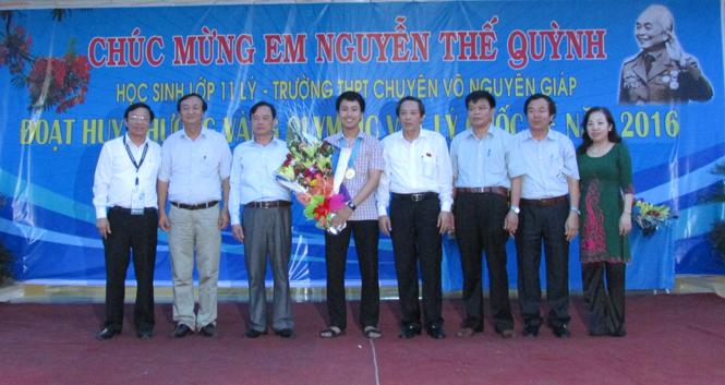 Các đồng chí lãnh đạo tỉnh, Sở GD - ĐT, Trường THPT chuyên Võ Nguyên Giáp tặng hoa chúc mừng em Nguyễn Thế Quỳnh.