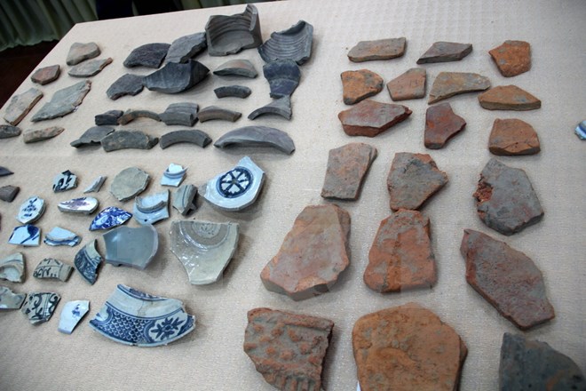 Một số hiện vật tìm thấy trong đợt khai quật được trưng bày tại buổi công bố. (Ảnh: Thanh Thủy/TTXVN)