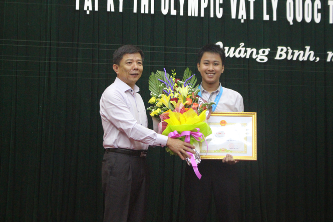 Đồng chí Nguyễn Hữu Hoài, Phó Bí thư Tỉnh ủy, Chủ tịch UBND tỉnh trao Bằng khen và phần thưởng cho em Nguyễn Thế Quỳnh.