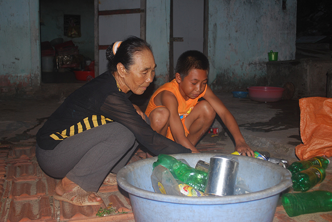  Hai bà cháu Nguyễn Trọng Thanh đang phân loại đồng nát để bán.