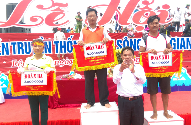 Đồng chí Nguyễn Quang Năm, Bí thư Huyện ủy, Chủ tịch UBND huyện trao giải Nhất, Nhì, Ba toàn đoàn cho các đội đua, bơi. 