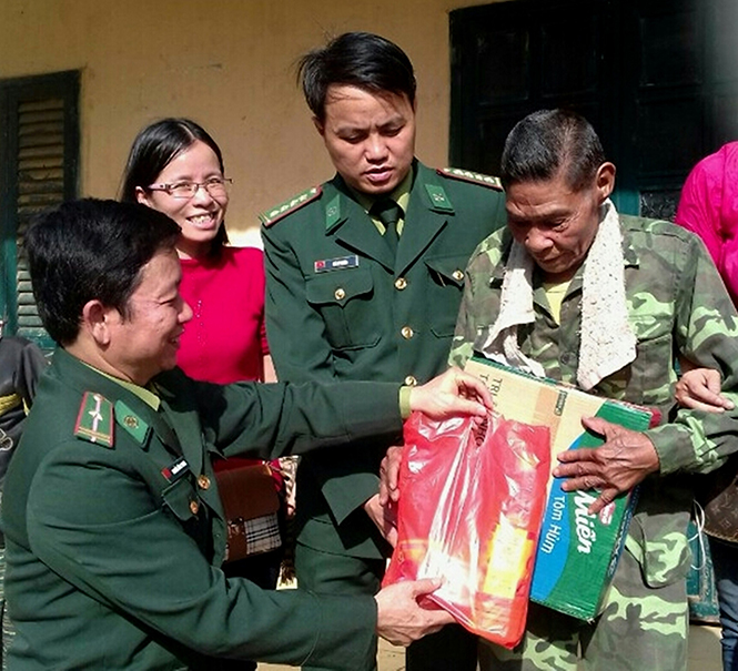 Anh Hồ Sỹ Nhân (ở giữa) trao quà cho bà con bản Lòm ở xã Trọng Hóa (Minh Hóa).
