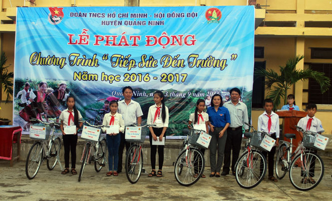 Đại diện lãnh đạo huyện Quảng Ninh, Huyện đoàn trao quà cho các em học sinh vượt khó, học giỏi.