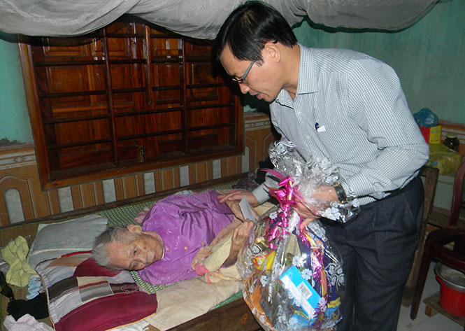Đồng chí Hoàng Hữu Thái, Quyền Tổng biên tập Báo Quảng Bình trao quà cho Bà mẹ Việt Nam anh hùng Cao Thị Tuyết.
