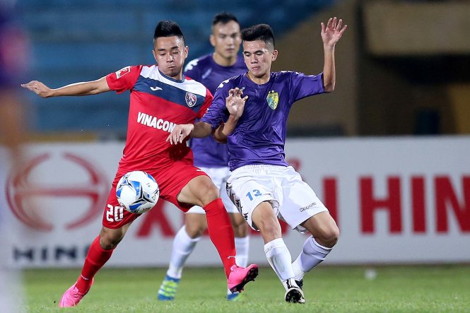 Một pha bóng trong trận Than Quảng Ninh (áo đỏ) thắng Hà Nội T&T 2-1. Ảnh: ANH HOÀNG