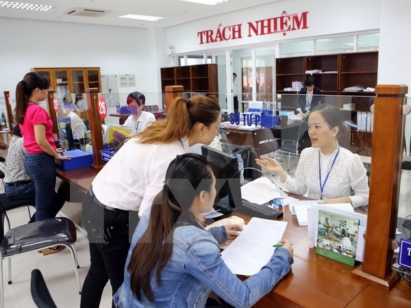 Hướng dẫn người dân giải quyết thủ tục hành chính tại khu vực giao dịch một cửa điện tử ở Trung tâm hành chính Đà Nẵng. (Ảnh minh hoạ: Trần Lê Lâm/TTXVN)