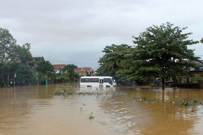 Mộ chiếc xe chở khách trị giá hàng trăm triệu đồng của người dân xã Lộc Thủy phải ngâm trong nước lũ.