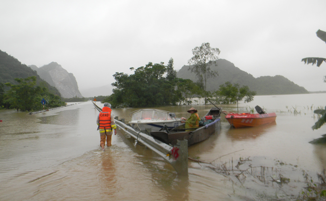 Các lực lượng chức năng huyện Tuyên Hoá nỗ lực tiếp cận một địa điểm bị lũ ngập sâu để giúp dân chống lũ.