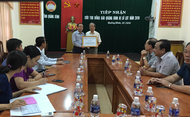 Đồng chí Trần Văn Tuân, Ủy viên Ban Thường vụ Tỉnh ủy, Chủ tịch Ủy ban MTTQVN tỉnh tiếp nhận cứu trợ từ đại diện Văn phòng Agribank khu vực miền Trung