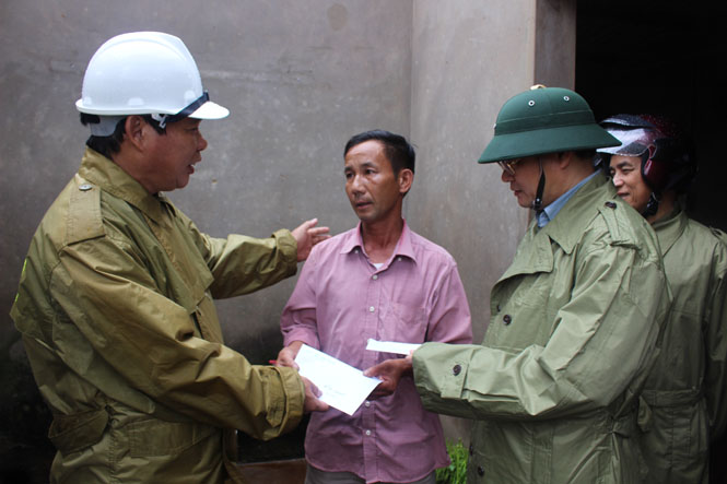 Đồng chí Nguyễn Quang Năm (bên trái) thăm, hỗ trợ gia đình người dân bị thiệt hại do mưa lũ tại xã Sen Thủy.