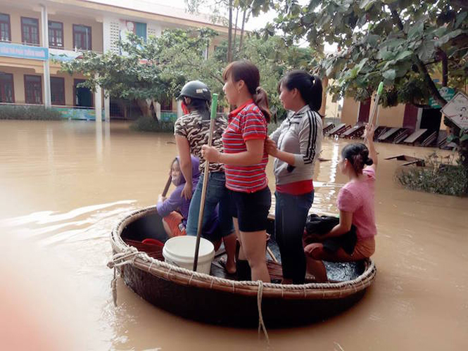 Các giáo viên Trường tiểu học số 2 Quảng Văn (thị xã Ba Đồn) đi lại dọn dẹp vệ sinh các dãy phòng học bằng thuyền thúng.