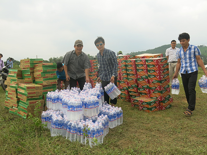 Cán bộ, lãnh đạo và phóng viên Báo Quảng Bình vận chuyển lương thực và nước uống về cứu trợ cho bà con vùng lũ huyện Minh Hóa.