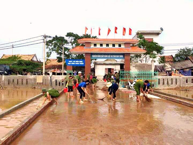 Lực lượng công an và đoàn viên thanh niên thị xã Ba Đồn hỗ trợ người dân làm vệ sinh môi trường tại xã Quảng Văn