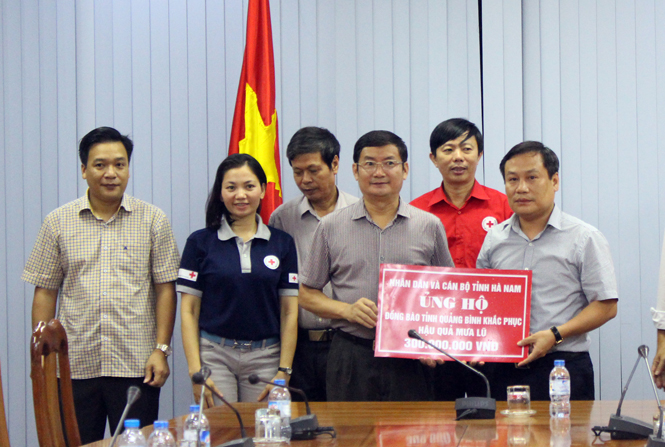 Đồng chí Phó Chủ tịch UBND tỉnh Trần Tiến Dũng tiếp nhận số tiền do Đảng bộ và nhân dân tỉnh Hà Nam hỗ trợ
