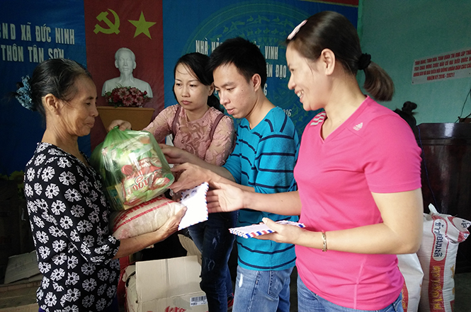 Bà Lê Thị Ngọc Thủy, Giám đốc Công ty cổ phần IQ Plus trao quà cho các hộ khó khăn trong lũ ở xã Đức Ninh, thành phố Đòng Hới.