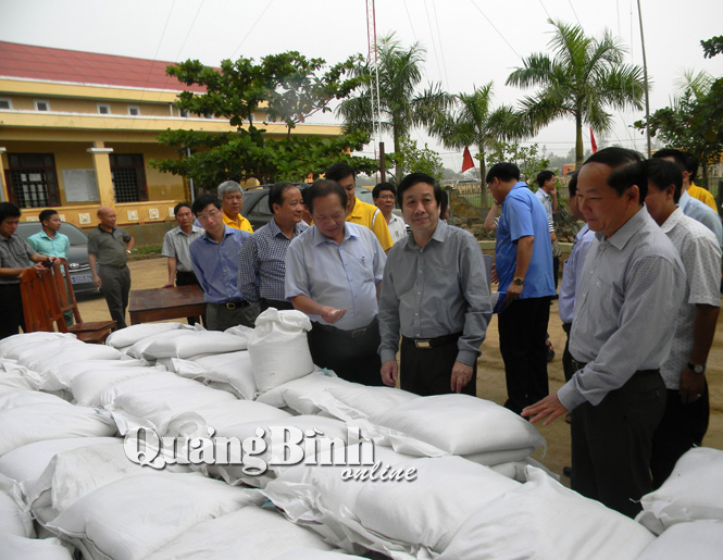 Bộ trưởng Bộ TT & TT Trương Minh Tuấn trực tiếp kiểm tra gạo trước khi trao cho người dân.