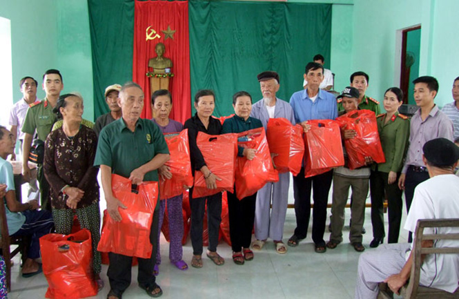 Đại diện Báo CAND và Công ty Duy Lợi trao quà hỗ trợ cho người dân xã Quảng Phúc, thị xã Ba Đồn.