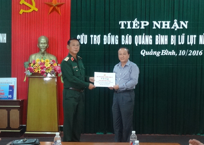 Đồng chí Trần Văn Tuân, Ủy viên Ban Thường vụ Tỉnh ủy, Chủ tịch Ủy ban MTTQVN tỉnh tiếp nhận cứu trợ của Bộ Tư lện Quân khu 7