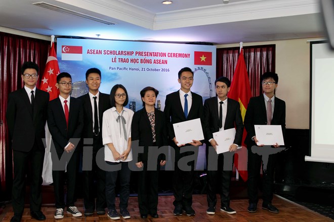 Đại sứ Singapore Catherine Wong (áo đen, ở giữa) chụp ảnh lưu niệm cùng các em học sinh nhận học bổng. (Ảnh: PV/Vietnam+)