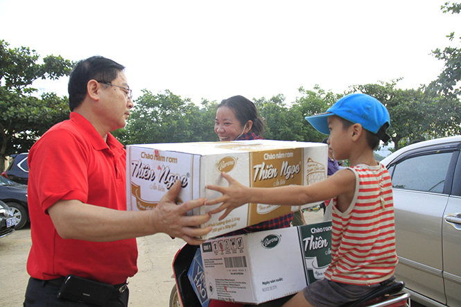 Ông Lê Xuân Sơn, Tổng Biên tập báo Tiền Phong hỗ trợ người dân nhận quà ủng hộ khắc phục lũ lụt.
