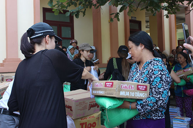 Ca sỹ Thu Minh đang tặng quà và tiền cho người dân vùng lũ Quảng Trạch
