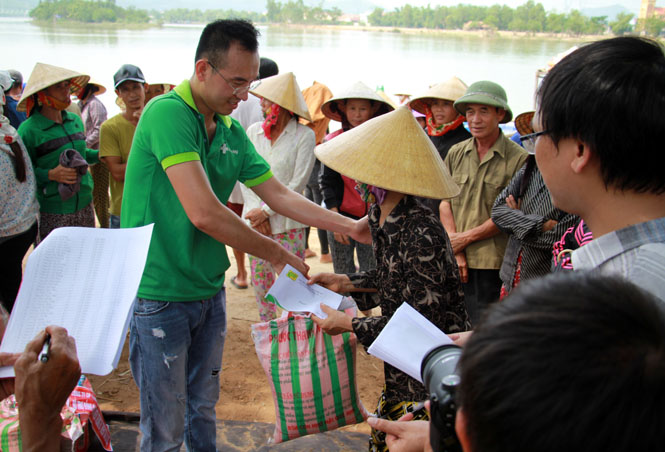 Bà con ở 4 thôn bãi bồi của xã Quảng Minh (thị xã Ba Đồn) nhận quà từ những người làm báo ở Nghệ An.
