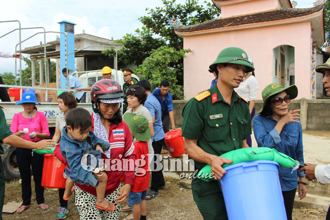 Cán bộ Ban Chỉ huy Quân sự huyện Lệ Thủy “xắn tay” giúp đỡ các thành viên gia đình Đại tướng Võ Nguyên Giáp trao quà cứu trợ cho người dân.