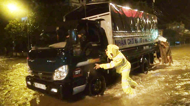 Cán bộ, chiến sĩ Phòng CSGT cứu hộ người và phương tiện trong mưa lũ.
