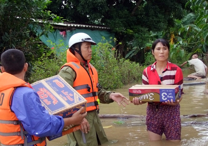 Lực lượng Công an tỉnh kịp thời tiếp cận vùng ngập lụt để cấp phát mì tôm, nước uống cho người dân.
