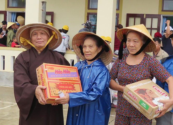 Hòa thượng Thích Hạnh Ngộ - Trưởng ban Trị sự Phật giáo quận 4, trụ trì chùa Đức Quang (TP. Hồ Chí Minh) trao quà cho bà con vùng lũ xã Mỹ Thủy (Lệ Thủy).