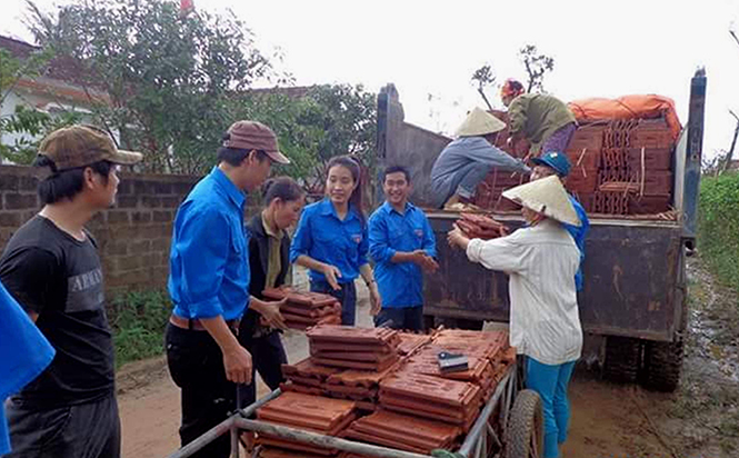 Thanh niên tình nguyện xã Bảo Ninh giúp người dân vận chuyển nguyên vật liệu để khắc phục và gia cố nhà cửa.
