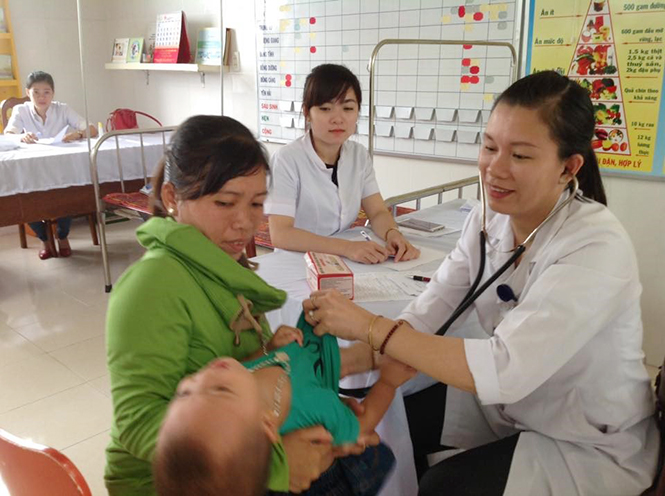 Cán bộ y tế đang khám bệnh cho người dân ở xã Cảnh Dương.