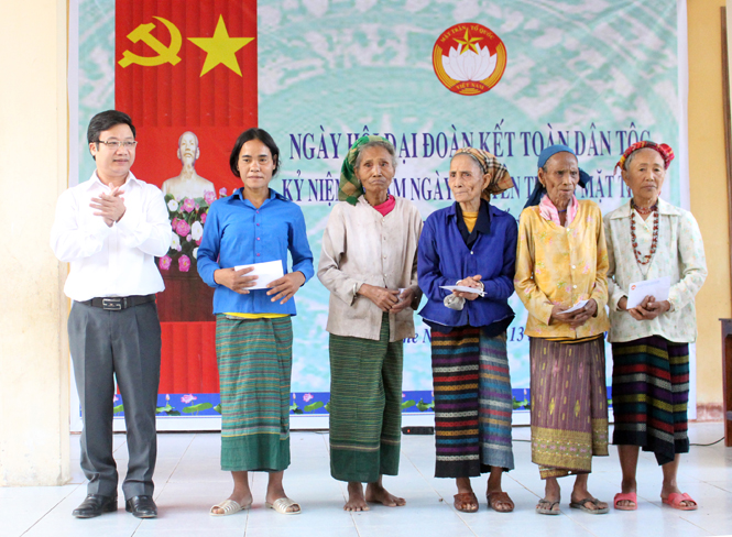Đồng chí Trưởng ban Tuyên giáo Tỉnh ủy trao quà cho các gia đình chính sách tại bản Khe Ngang.