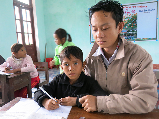 Thầy giáo Hồ Tiến Nam đang dạy học cho các em nhỏ đồng bào Rục.