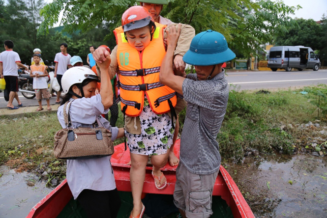 Giữa đỉnh lũ, thai phụ Trần Thị Mai được đưa đi bệnh viện bằng ca-nô.
