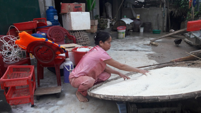 Bà Hoàng Thị Vân đang phơi số gạo bị ngâm trong nước lũ.