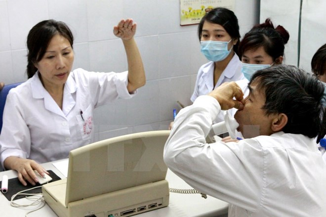 Bác sỹ hướng dẫn người bệnh đo chức năng hô hấp. (Ảnh: TTXVN/Vietnam+)