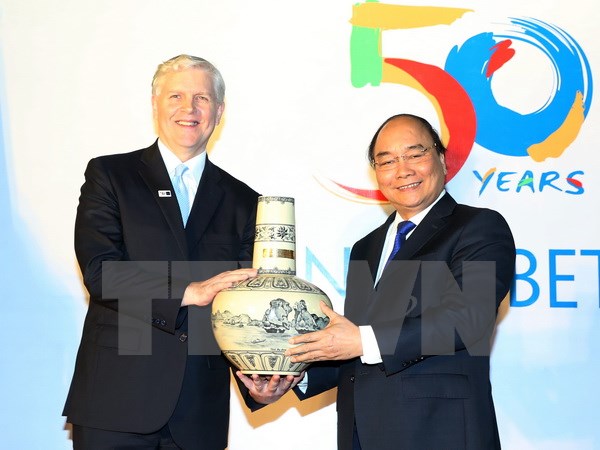 Thủ tướng Nguyễn Xuân Phúc tặng quà cho Giám đốc quốc gia Ngân hàng Phát triển châu Á Eric Sidgwick. (Ảnh: Thống Nhất/TTXVN)