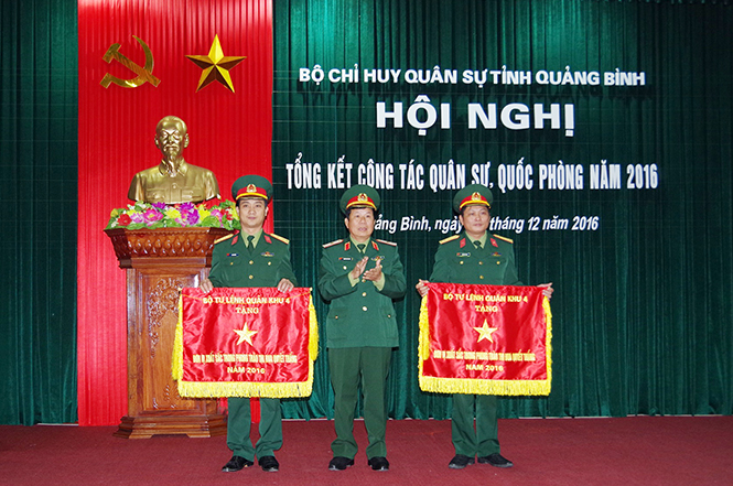Thiếu tướng Nguyễn Văn Hiếu trao Cờ thi đua quyết thắng của Bộ Tư lệnh Quân khu 4 cho Ban CHQS huyện Tuyên Hóa và Ban CHQS huyện Minh Hóa.
