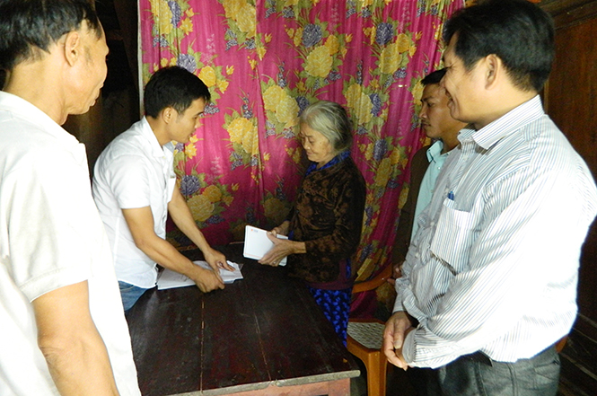 Đại diện các tổ chức thiện nguyện hỗ trợ tiền để sửa chữa, nâng cấp nhà ở cho hộ nghèo xã Quảng Tân.