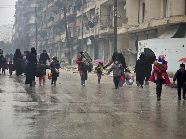 Người dân Syria sơ tán khỏi các khu vực do quân nổi dậy kiểm soát để đến các khu vực đã được quân Chính phủ giải phóng ở Aleppo ngày 13-12. (Nguồn: AFP/TTXVN)