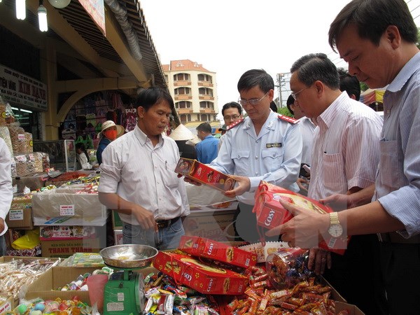 Đoàn Thanh tra Bộ Y tế và thanh tra liên ngành Thành phố Hồ Chí Minh kiểm tra bánh mứt Tết tại chợ Bình Tây. (Ảnh: Phương Vy/TTXVN)